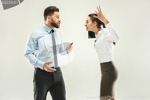 Image of Angry boss. Man and his secretary standing at office or studio