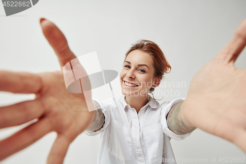 Image of Young woman smiling with her arms open on white background