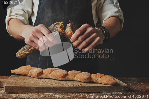 Image of hands men break the baguette