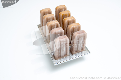 Image of Plastic molds with coffee homemade ice cream on white background