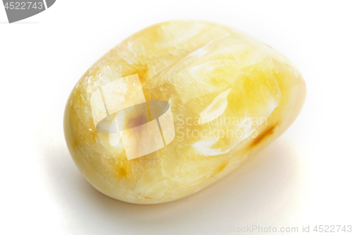 Image of Natural amber. A piece of yellow opaque natural amber on white background.