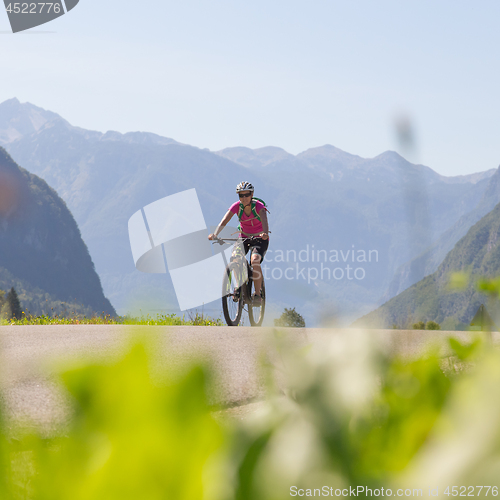 Image of Active sporty woman riding mountain bike in nature.