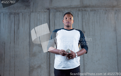 Image of black business man displaying a spread of american dollar cash m