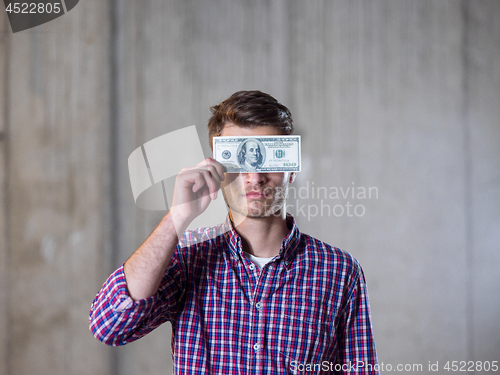 Image of business man holding american dollars banknote over the eyes