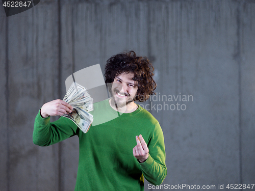 Image of business man displaying a spread of american dollar cash money