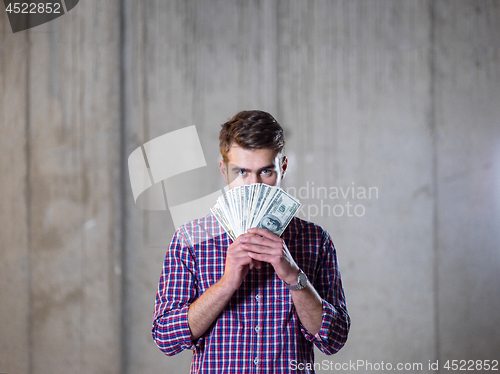 Image of business man displaying a spread of american dollar cash money