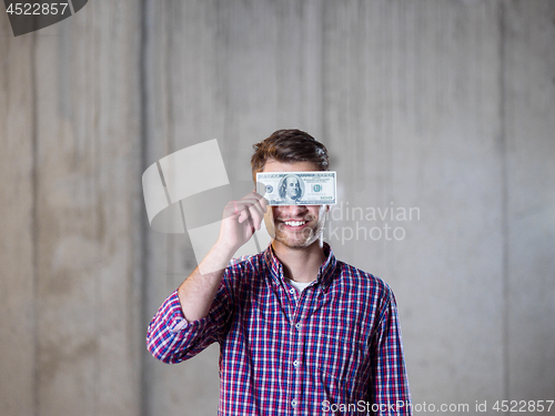 Image of business man holding american dollars banknote over the eyes