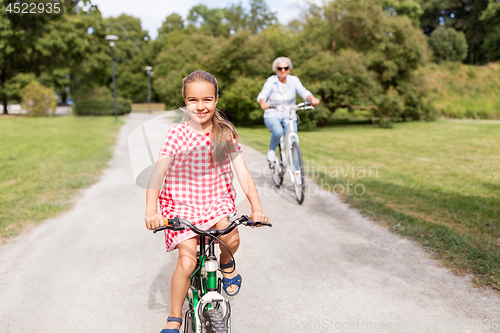 Image of grandmother and granddaughter cycling at park