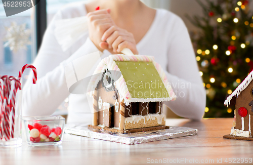 Image of woman making gingerbread houses on christmas