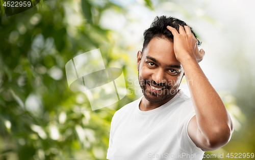 Image of indian man touching his hair