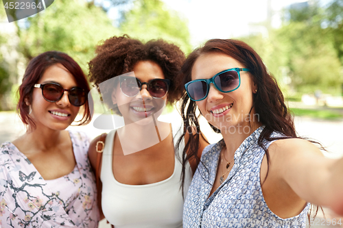 Image of happy young women in sunglasses at summer park