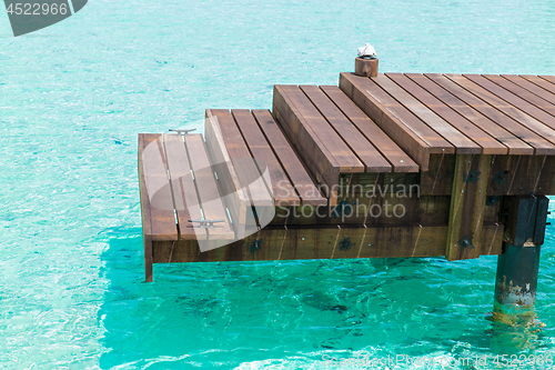 Image of wooden pier with stair in sea water