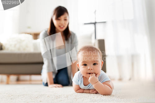 Image of sweet little asian baby boy with mother at home