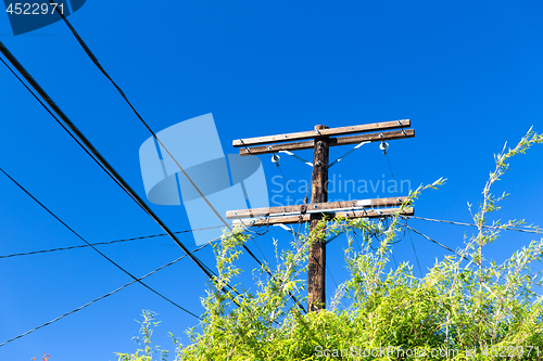 Image of transmission tower and power line over blue sky