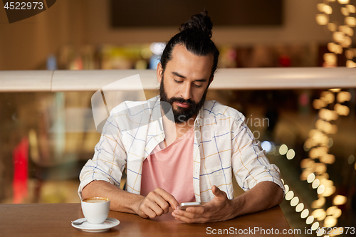Image of man with coffee and smartphone at restaurant