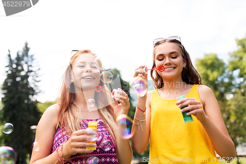 Image of teenage girls blowing bubbles at summer park