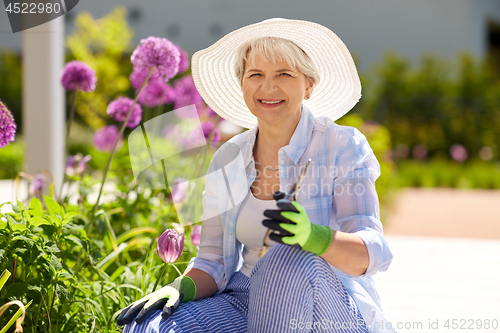 Image of senior woman with garden pruner and flowers