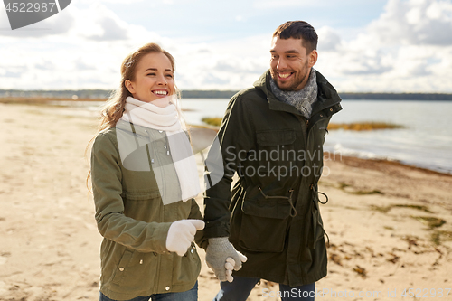 Image of couple walking along autumn beach