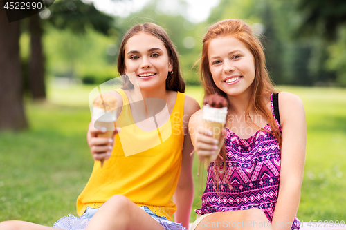 Image of teenage girls eating ice cream at picnic in park