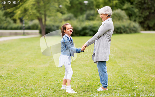 Image of grandmother and granddaughter playing at park