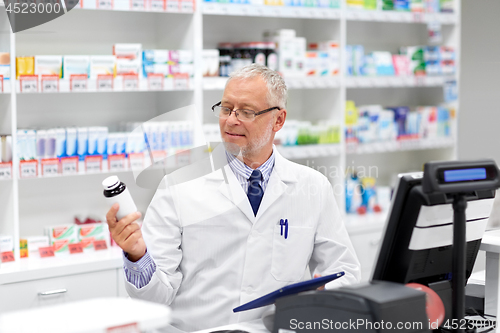 Image of senior apothecary with drug at pharmacy