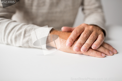 Image of senior man hands on table
