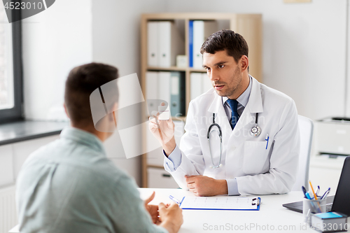 Image of doctor showing medicine to patient at hospital