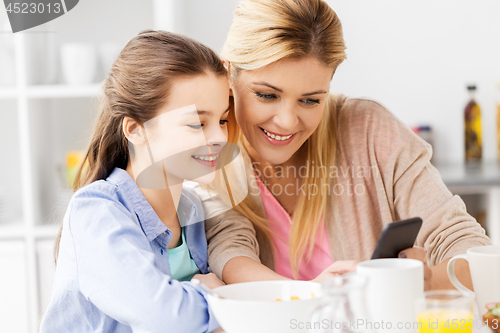 Image of family with smartphone having breakfast at home