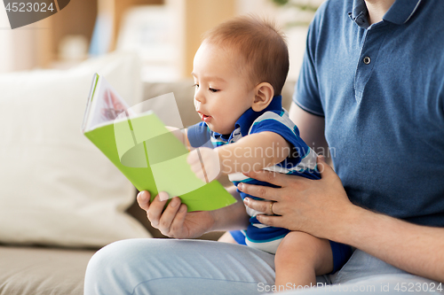 Image of baby boy and father with book at home