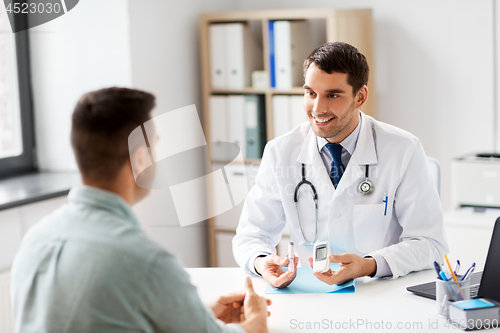 Image of doctor with glucometer and patient at hospital