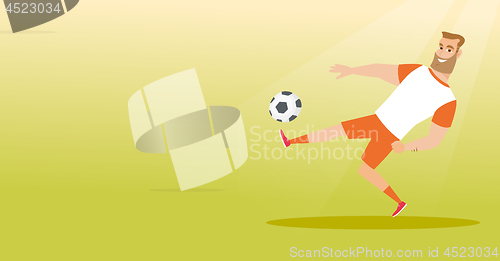 Image of Young caucasian soccer player kicking a ball.