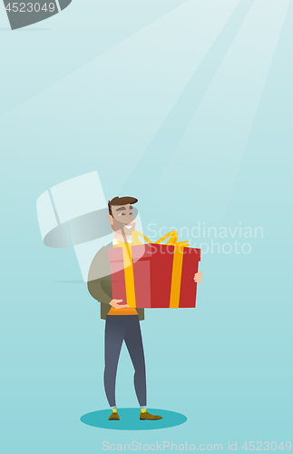Image of Young caucasian man holding box with gift.