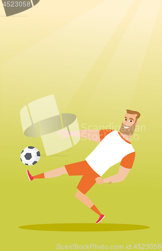 Image of Young caucasian soccer player kicking a ball.