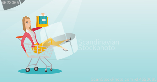 Image of Young caucasian woman riding in shopping trolley.