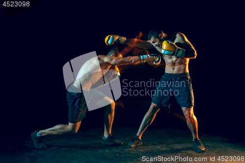 Image of Male boxer boxing in a dark studio