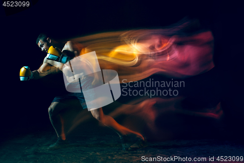 Image of Male boxer boxing in a dark studio