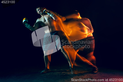 Image of Male boxer boxing in a dark studio