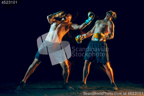Image of Male boxer boxing in a dark studio