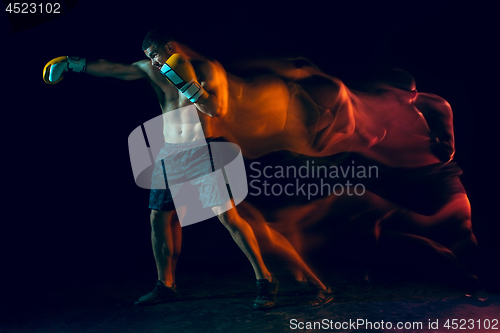 Image of Male boxer boxing in a dark studio