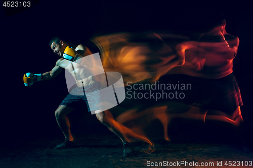 Image of Male boxer boxing in a dark studio