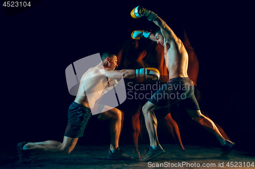 Image of Male boxer boxing in a dark studio