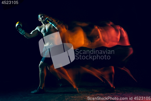 Image of Male boxer boxing in a dark studio