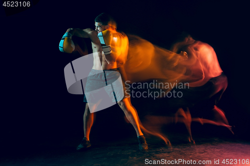 Image of Male boxer boxing in a dark studio