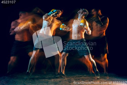 Image of Male boxer boxing in a dark studio