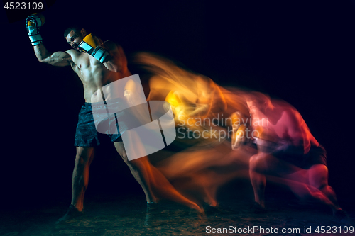 Image of Male boxer boxing in a dark studio