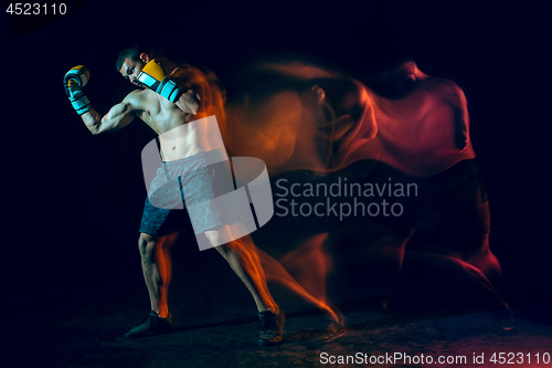 Image of Male boxer boxing in a dark studio