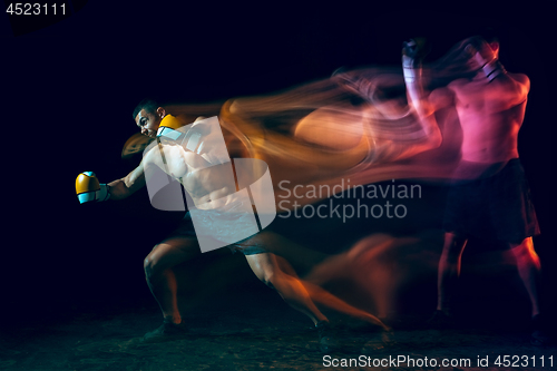 Image of Male boxer boxing in a dark studio