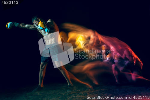 Image of Male boxer boxing in a dark studio