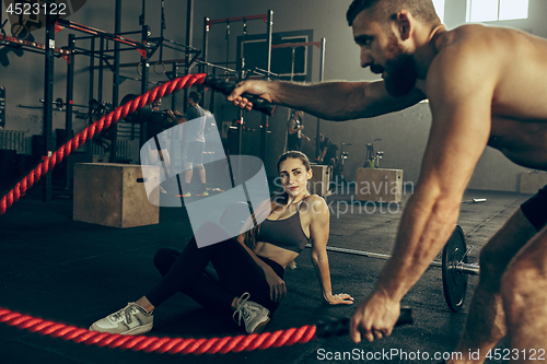 Image of Men with battle rope battle ropes exercise in the fitness gym.