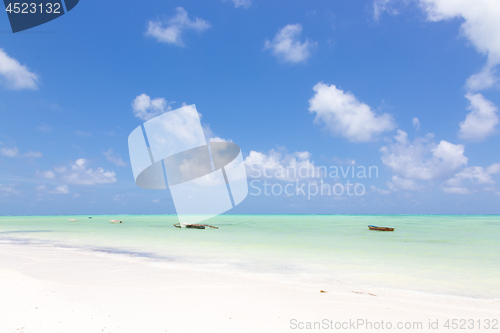 Image of Traditional wooden fishing boats on picture perfect white sandy beach with turquoise blue sea, Paje, Zanzibar, Tanzania.